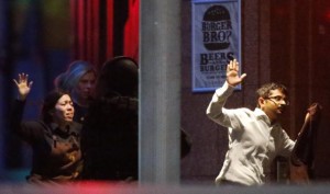 Beberapa sandera berhasil keluar dari kafe tempat tragedi penyanderaan, Selasa (16/12) di Sydney, Australia.  (Sumber foto: Reuters)